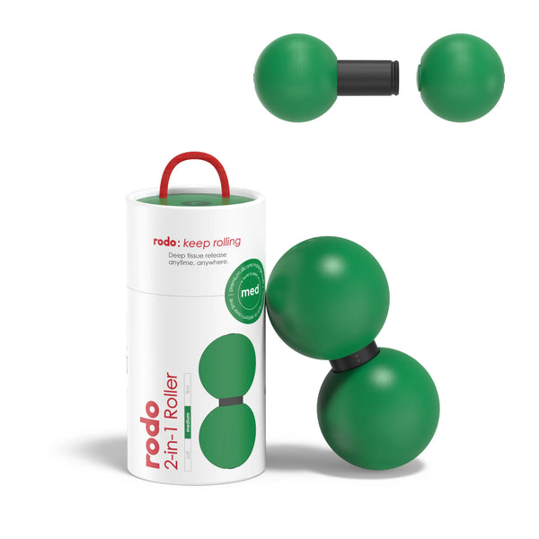 Green massage roller with black straps and red handle next to its packaging on a white background